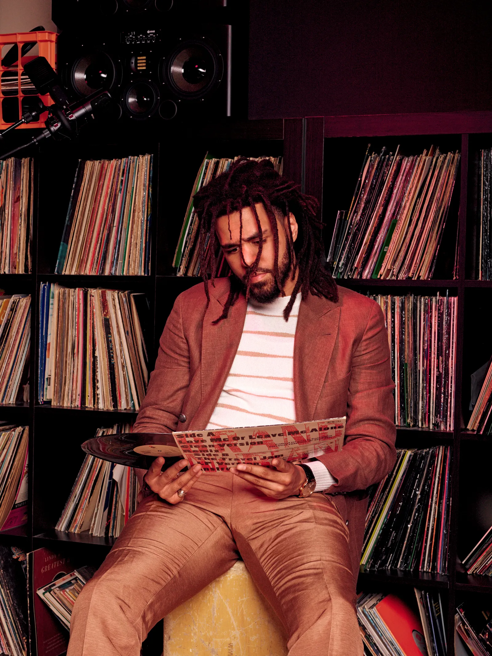 J.cole picture of him sitting starting at a vinyl